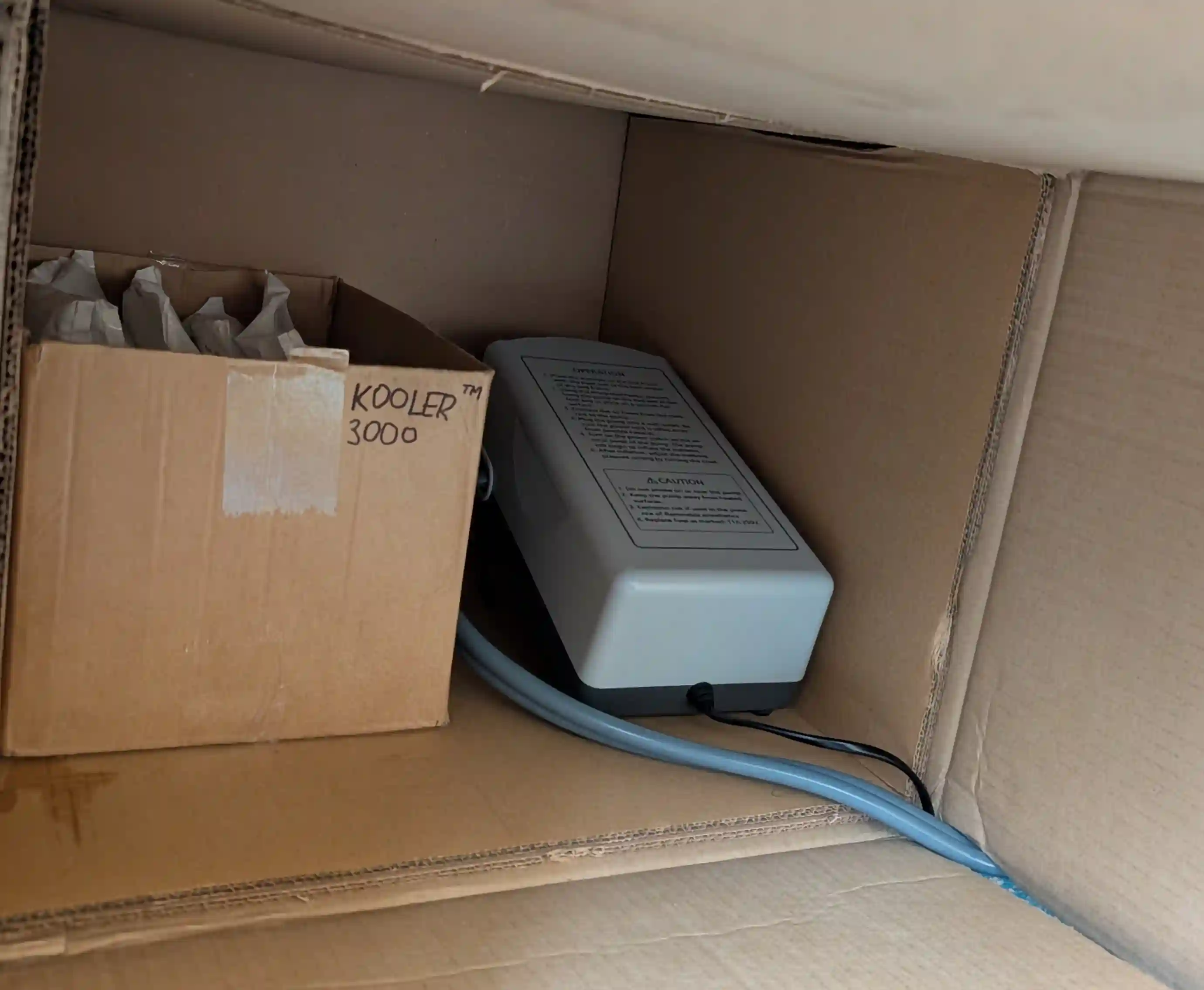 A box of ice gel packs and a mattress compressor within a large cardboard box A box of ice gel packs and a mattress compressor within a large cardboard box
